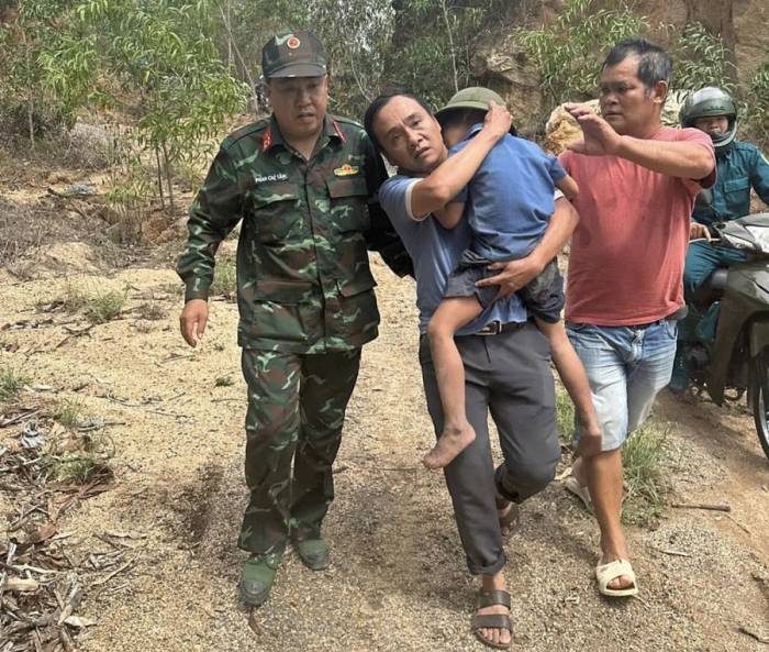 Lực lượng chức năng hỗ trợ đưa bé trai xuống núi. Ảnh: Công an phường Sông Cầu