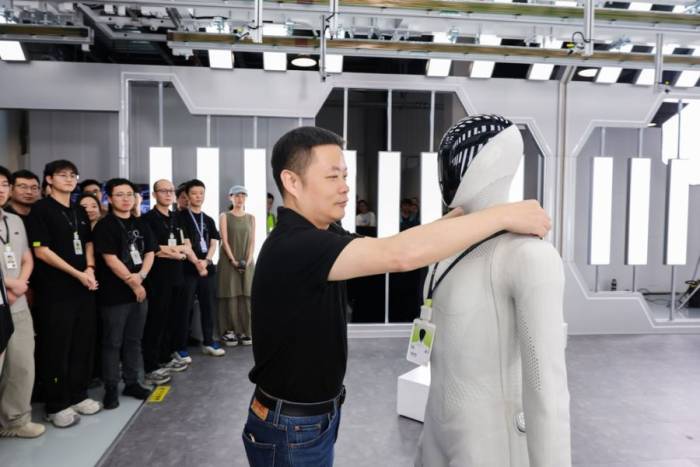 CEO He Xpeng Xiaopeng đeo thẻ nhân viên cho robot hình người Iron. Ảnh: Xpeng