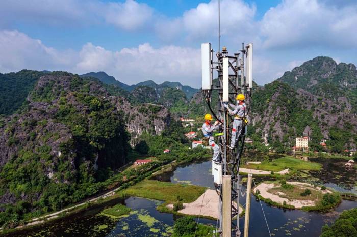 Kỹ thuật viên làm việc trên cột phát sóng của một nhà mạng. Ảnh: Thọ Trần