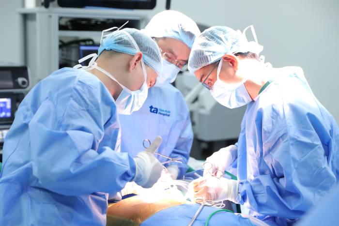Bác sĩ Thái (trái) đang phẫu thuật cho anh Minh. Ảnh: Bệnh viện Đa khoa Tâm Anh