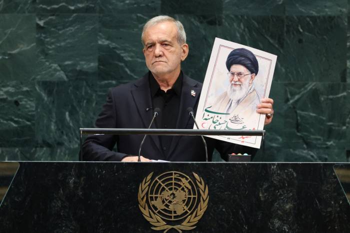Tổng thống Masoud Pezeshkian phát biểu khi cầm bức ảnh của cố lãnh tụ tối cao Iran Ali Khamenei tại khóa họp 81 của Đại hội đồng Liên Hợp Quốc ở New York ngày 23/9. Ảnh: AFP