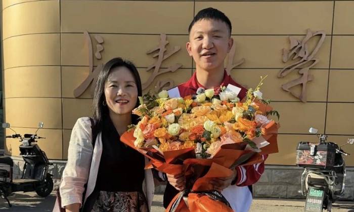 Cô Zhang Long (trái) cùng Guo Bin đến Đại học Trường Xuân, tỉnh Cát Lâm nhập học ngày 6/9. Ảnh: Jimu News