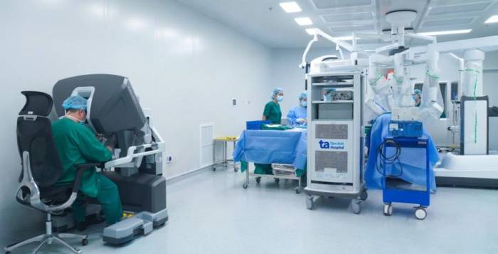 Bác sĩ Đức (ngồi) điều khiển robot Da Vinci Xi phẫu thuật triệt căn ung thư tuyến tiền liệt cho người bệnh. Ảnh: Bệnh viện Đa khoa Tâm Anh