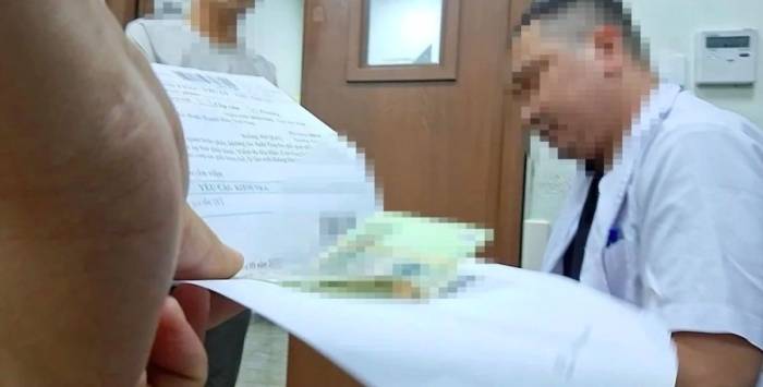 Tiền mệnh giá 100.000 đồng được kẹp trong sổ xạ trị. Ảnh: Báo Nông nghiệp và Môi trường