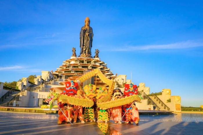 Múa lân sư rồng dưới chân tượng Phật Bà Tây Bổ Đà Sơn tại đỉnh núi Bà Đen. Ảnh: Sun World Ba Den Mountain