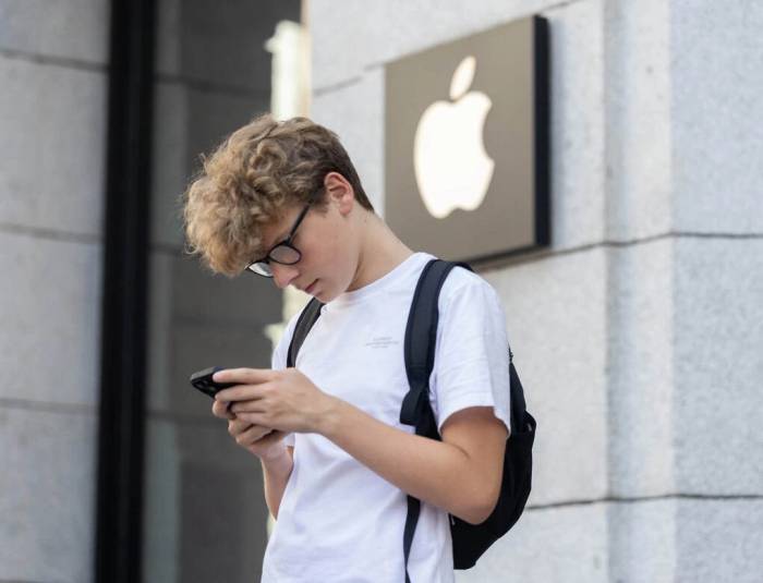 Một người dùng đang đi ngang cửa hàng Apple. Ảnh: CNBC