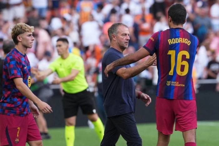 HLV Hansi Flick (áo đen) chia vui cùng Rodri sau trận Barca thắng Valencia 5-0 ở vòng bốn La Liga, trên sân Mestalla, Valencia, Tây Ban Nha, ngày 6/9/2026. Ảnh: AP