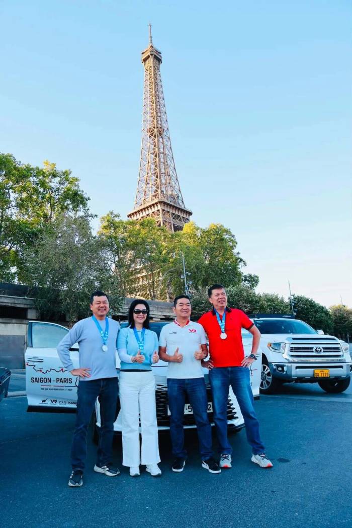 Ảnh Hải (thứ hai từ phải sang) chụp ảnh tại Paris, Pháp, bên chiếc xe tự lái từ Việt Nam vào ngày 11/9.