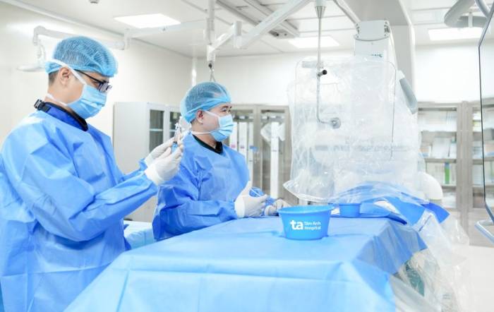 Êkíp can thiệp nội mạch cho anh Khánh dưới hướng dẫn của hệ thống chụp mạch số hóa xóa nền (DSA). Ảnh: Bệnh viện cung cấp