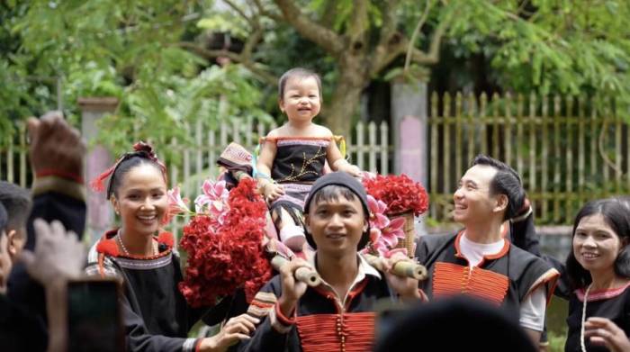 Bé Harley ngồi kiệu có hai người khiêng tại bữa tiệc.