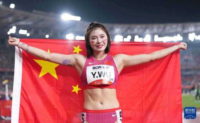 Wu Yanni bật khóc khi khoác quốc kỳ Trung Quốc sau khi giành HC đồng 100 m rào nữ với thành tích 13,12 giây tại sân Mizuho, Nagoya, Nhật Bản tối 27/9/2026. Ảnh: Xinhua
