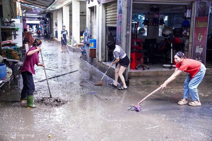 Tiểu thương chợ Vinh dọn dẹp cửa hàng, sáng 20/9. Ảnh: Đức Hùng
