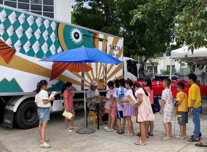 Các em nhỏ giao lưu và chờ họa sĩ Trần Đại Thắng vẽ bìa sách tại Thư viện tỉnh Gia Lai (phường Quy Nhơn, Gia Lai). Ảnh: Nhân vật cung cấp