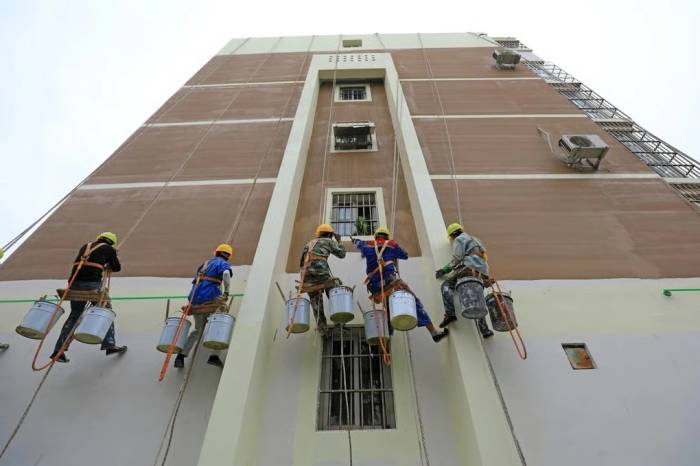 Công nhân xây dựng treo mình trên dây để sơn tường bên ngoài một tòa nhà tại huyện Loan Nam, tỉnh Hà Bắc, Trung Quốc. Ảnh: SCMP