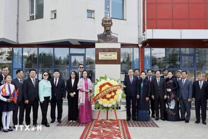 Chủ tịch Quốc hội Trần Thanh Mẫn và phu nhân cùng đại biểu chụp ảnh lưu niệm tại tượng đài Chủ tịch Hồ Chí Minh trong khuôn viên trường. Ảnh: TTXVN