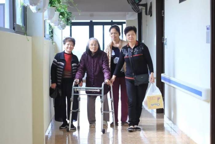 Một cụ già gặp khó khăn vận động, sống trong viện dưỡng lão ở Thanh Trì, Hà Nội được bạn bè tới thăm, năm 2021. Ảnh: Phan Dương