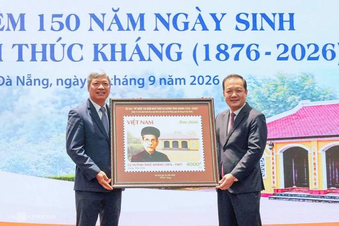 Thứ trưởng Bộ Khoa học và Công nghệ Phạm Đức Long (bên phải) trao tặng bức tranh tem cho Phó chủ tịch UBND thành phố Hồ Quang Bửu. Ảnh: Đồng Công