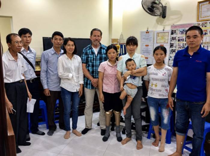 Bác sĩ Lê Thành Đô (ngoài cùng bên trái) cùng nhà tài trợ người Mỹ Rodd Mann (áo caro) đến thăm các bệnh nhân được lắp chân, tay giả tại Hà Nội, ngày 18/6/2018. Ảnh: Nhân vật cung cấp