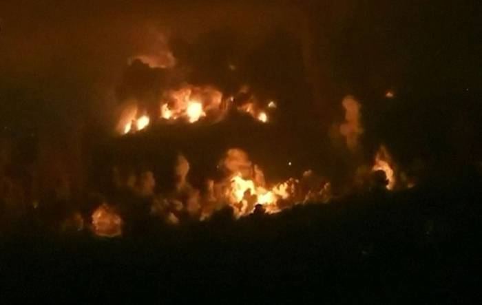 Lửa bốc lên khi Israel kích nổ cơ sở ngầm ở đồi Ali al-Taher. Ảnh: AFP