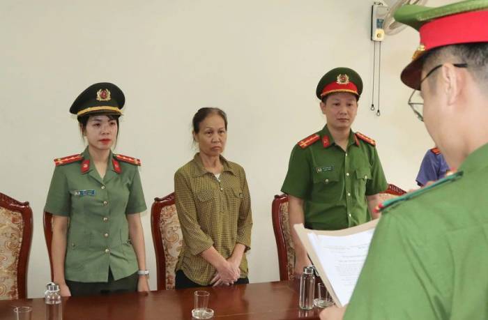 Công an đọc lệnh khởi tố bà Tưởng Thị Hòe. Ảnh: Cao Thiên