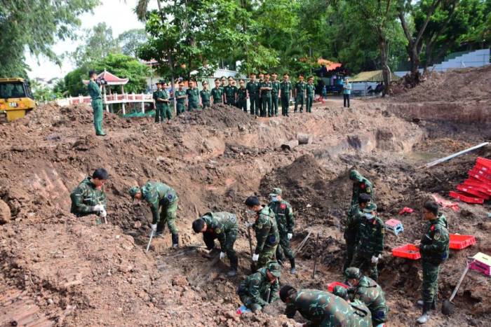 Lực lượng  chức năng tìm kiếm hài cốt liệt sĩ tại hố chôn dài hơn 30 m ở công viên Lê Thị Riêng. Ảnh: Nguyễn Hùng