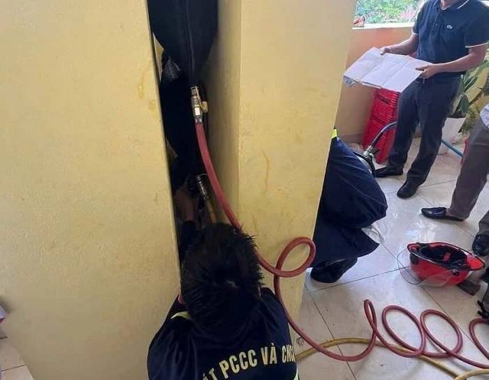 Cảnh sát cứu hộ dùng gối nâng chèn giữa khe hở trong quá trình giải cứu bé trai. Ảnh: Lực lượng cứu hộ cung cấp