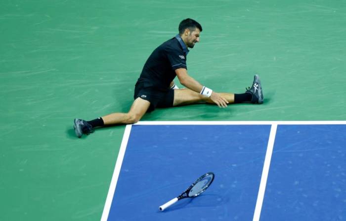 Novak Djokovic ngồi trên sân trong trận đấu trước Mariano Navone ở vòng một Mỹ Mở rộng 2026, trên sân Arthur Ashe, New York, Mỹ ngày 30/8/2026. Ảnh: Reuters
