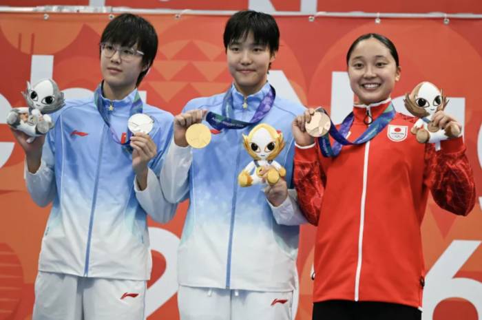 Yu Zidi (giữa) giành HC vàng, đứng giữa trên bục nhận huy chương cùng đồng hương Ke Wenxi, người giành HC bạc, và VĐV Nhật Bản Mio Narita, giành HC đồng, tại Tokyo, Nhật Bản, ngày 23/9/2026. Ảnh: AFP