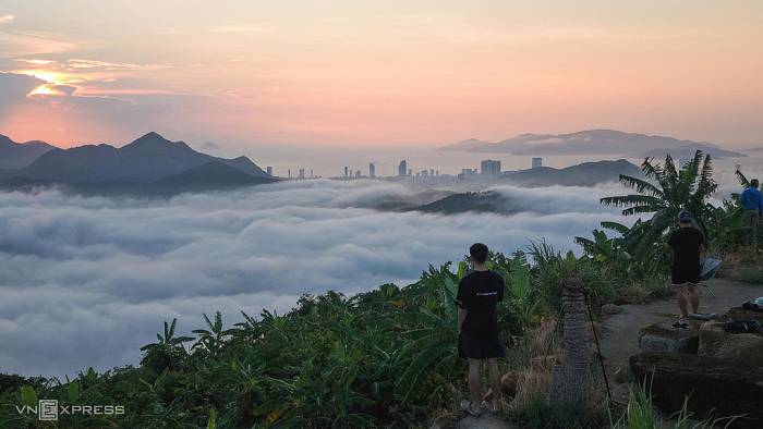 Anh Hoàng Sơn chiêm ngưỡng cảnh mây bao quanh các sườn núi, khu dân cư ở Nha Trang. Ảnh: Bùi Toàn