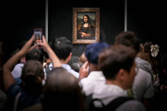 Du khách ngắm bức tranh Mona Lisa của danh họa Leonardo da Vinci tại bảo tàng Louvre ở Paris, Pháp ngày 22/7. Ảnh: AFP