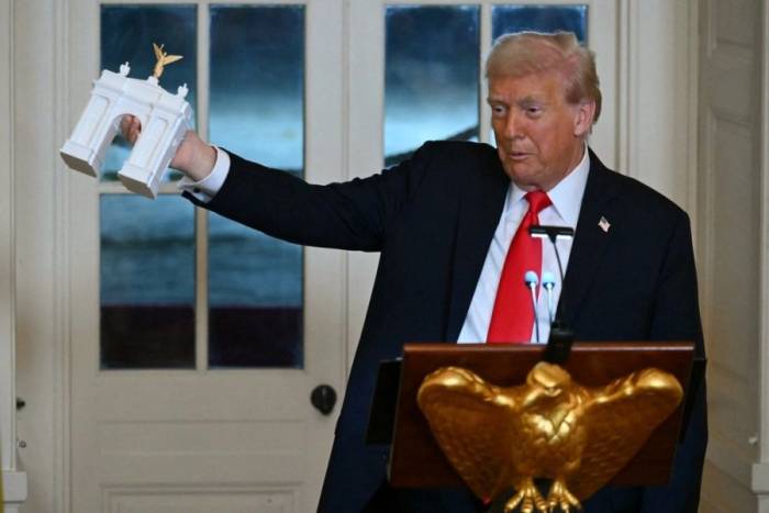 Tổng thống Trump cầm mô hình khải hoàn môn do ông đề xuất tại một bữa tiệc ở Nhà Trắng tháng 10/2025. Ảnh: AFP