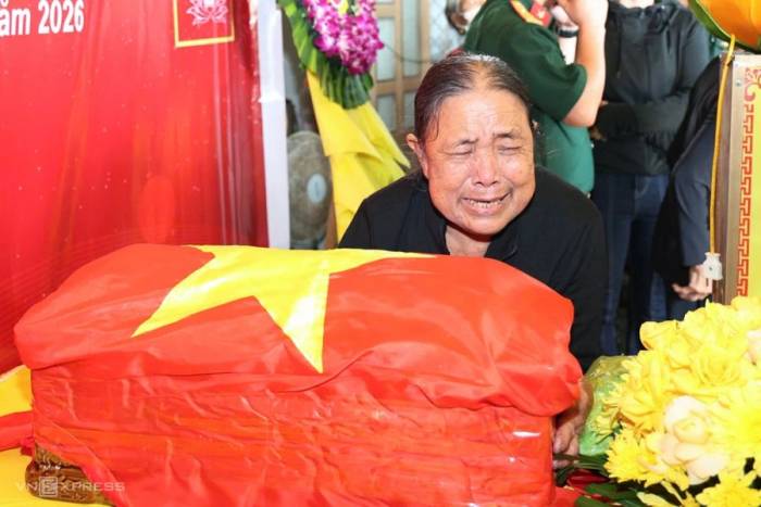 Bà Miện xúc động khi nhìn quan tài đựng hài cốt của chồng Phan Hồng Viêm. Ảnh: Lan Ánh