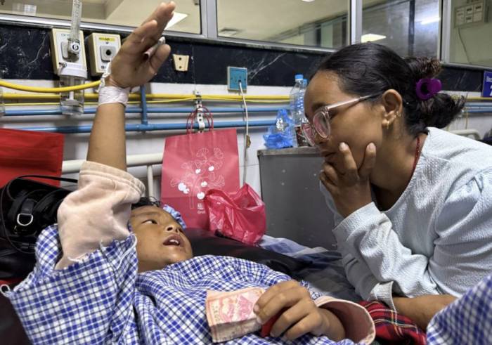 Zoyal Ghale, 8 tuổi, kể lại sự việc cho mẹ, chị Matti Maya Tamang, tại bệnh viện ở Kathmandu, Nepal hôm 28/8. Ảnh: Reuters