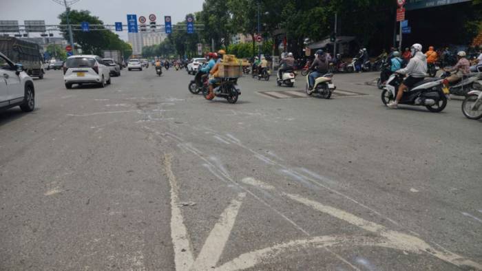 Vết cày kéo dài hơn 10 m trên mặt đường do ôtô kéo xe máy dưới gầm. Ảnh: Đình Văn