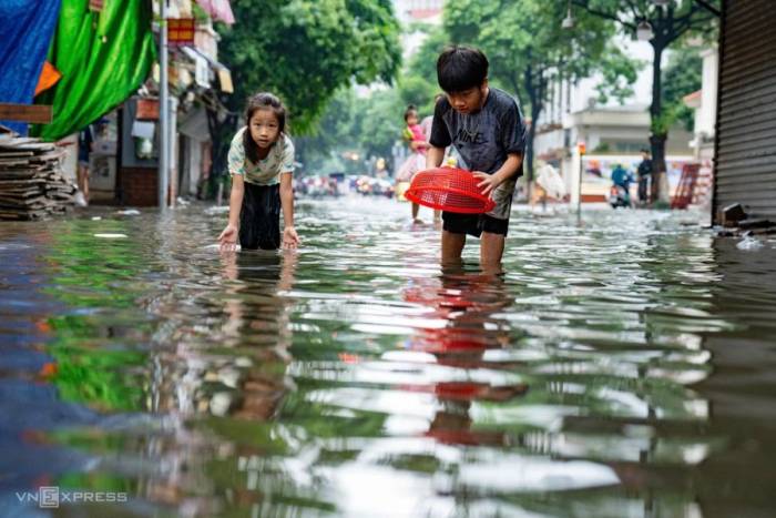 Trẻ nhỏ bắt cá trên phố Phan Văn Trường - nơi còn ngập tới 40 cm lúc 16h30 chiều 17/9. Ảnh: Tùng Đinh