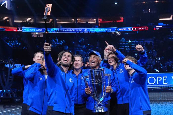 Alcaraz chụp ảnh selfie khi đội trưởng Yannick Noah nâng Cup cùng các thành viên đội châu Âu, sau chiến thắng 13-5 trước đội Thế giới tại nhà thi đấu O2, London, Anh ngày 27/9/2026. Ảnh: AP