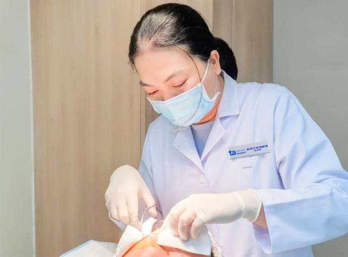 Bác sĩ Hải kiểm tra, vệ sinh vết mổ của chị Dương. Ảnh: Bệnh viện Đa khoa Tâm Anh