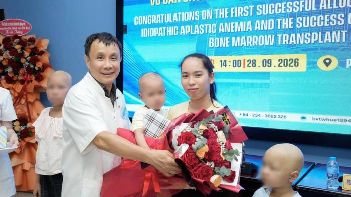 GS.TS Phạm Như Hiệp tặng hoa cho bệnh nhi ra viện. Ảnh: Bác sĩ Trâm