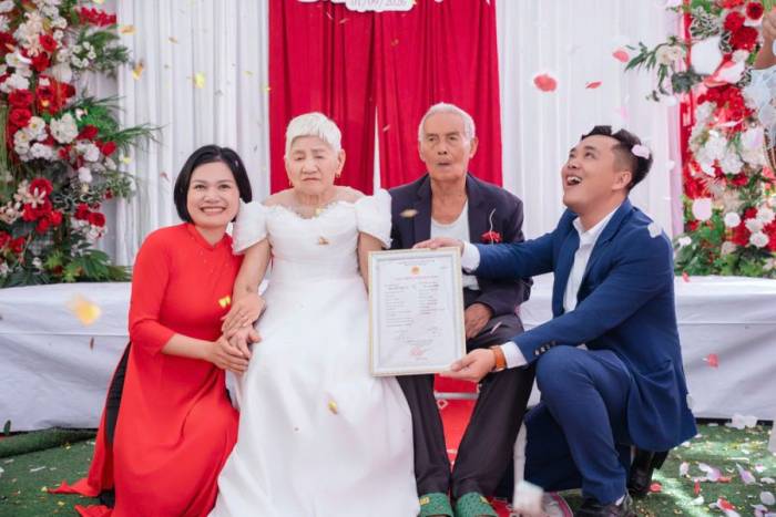 Vợ chồng anh Đức Linh, chị Hương Trà trao giấy đăng ký kết hôn tượng trưng cho ông bà nội trong đám cưới lại ngày 1/9, tại phường Yên Dũng, tỉnh Bắc Ninh. Ảnh: Hương Trà