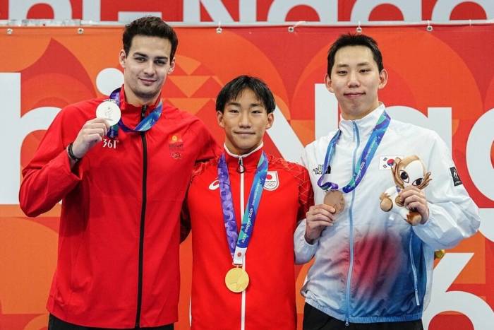 VĐV người Nhật Bản Shin Ohashi (giữa) giành HC vàng bơi 200m ếch ASIAD 2026, và lập kỷ lục thế giới với 2 phút 4 giây 83, tại Cung thể thao dưới nước Tokyo, Nhật Bản ngày 24/9/2026. Ảnh: AFP