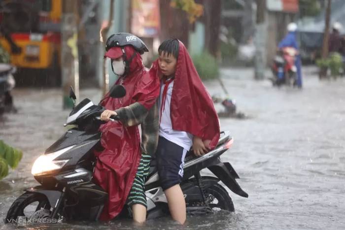 Phụ huynh, học sinh lội nước trong cơn mưa lớn chiều 23/9. Ảnh: Quỳnh Trần