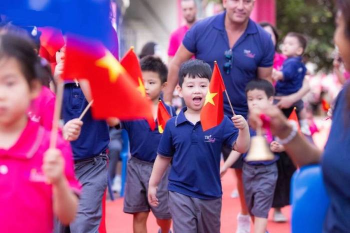 Học sinh tiểu học được thầy cô đưa vào trường trong lễ khai giảng. Ảnh: TH School