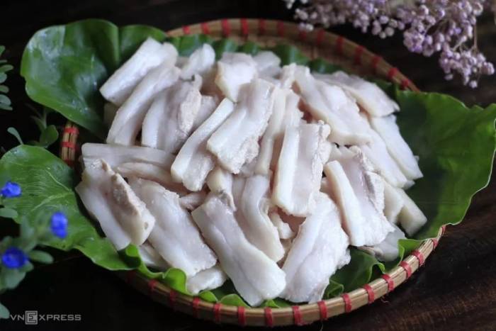 Luộc mỡ lợn trước khi rán để làm sạch tạp chất, khử mùi. Ảnh: Bùi Thủy