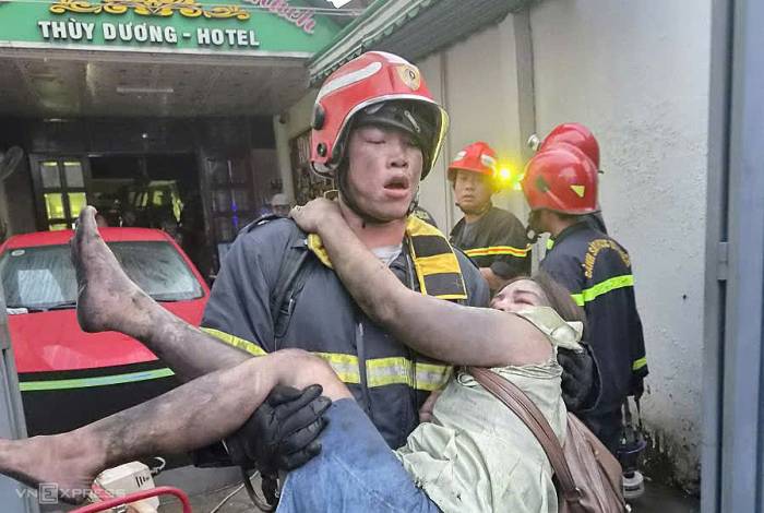 Cảnh sát cứu hỏa cứu nạn nhân ra khỏi vụ cháy. Ảnh: Đình Văn