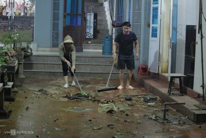 Người dân dọn nhà khi nước rút. Ảnh: Quốc Dũng