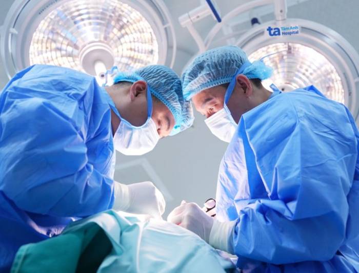 Bác sĩ Sơn (phải) phẫu thuật cho bà Kim. Ảnh: Bệnh viện Đa khoa Tâm Anh