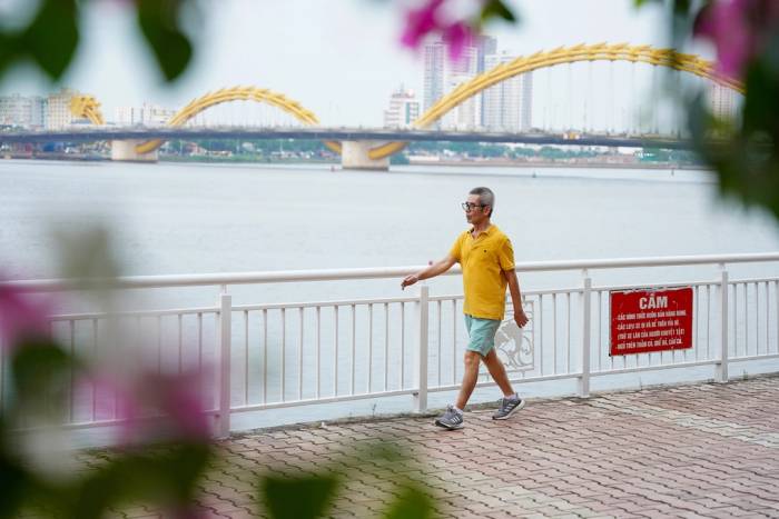 Người đàn ông đi bộ tập thể dục trên bờ kè ven sông Hàn, Đà Nẵng. Ảnh: Nguyễn Đông