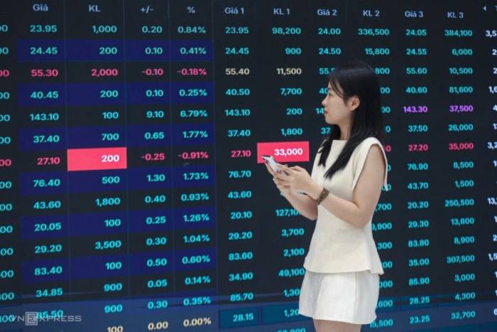 Nhà đầu tư đang theo dõi bảng giá điện tử tại một công ty chứng khoán ở TP HCM. Ảnh: Quỳnh Trần