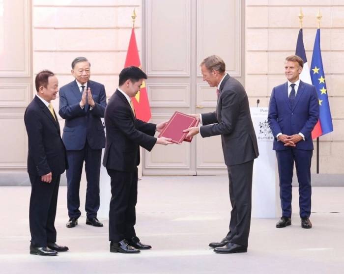 Ông Đỗ Quang Hiển, Nhà sáng lập, Chủ tịch Điều hành T&T Group (bìa trái) cùng ông Đỗ Vinh Quang, Phó Chủ tịch T&T Group, Chủ tịch Vietravel Airlines và ông Wouter van Wersch, Chủ tịch Airbus International trao thỏa thuận hợp tác mua 50 máy bay thế hệ mới. Ảnh: