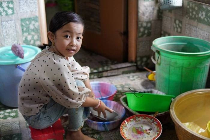 Cô học trò lớp 2 thường giành phần rửa bát, dọn dẹp để phụ mẹ đi lại khó khăn. Ảnh: Ngọc Hân